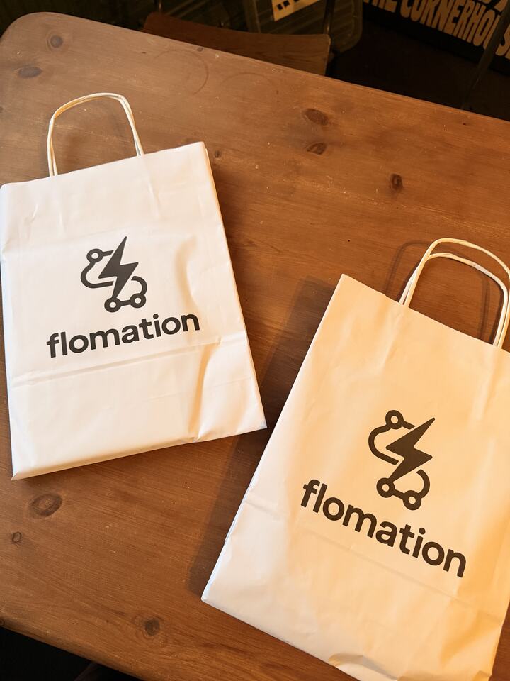 Two Flomation paper bags on a wooden table
